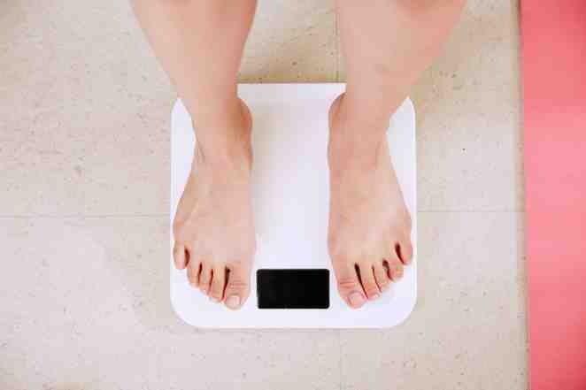 Person standing on digital bathroom scale.