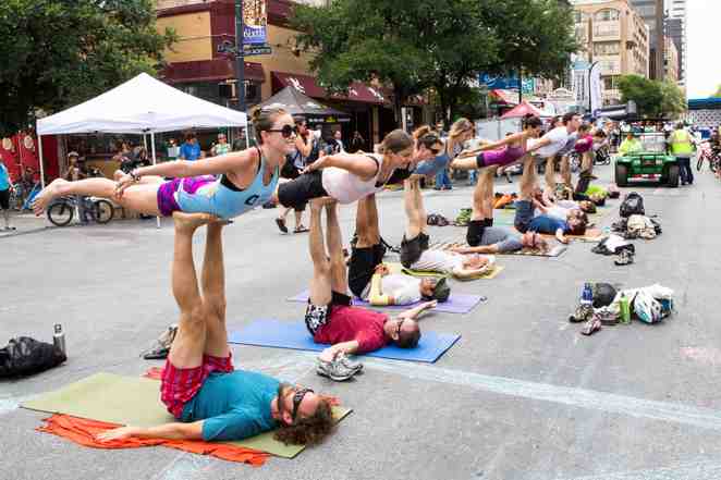Acro yoga on the street in downtown Austin, Texas. This is bird - the most basic acro yoga pose.