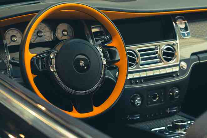 Orange leather steering wheel and dashboard of an iconic Rolls Royce