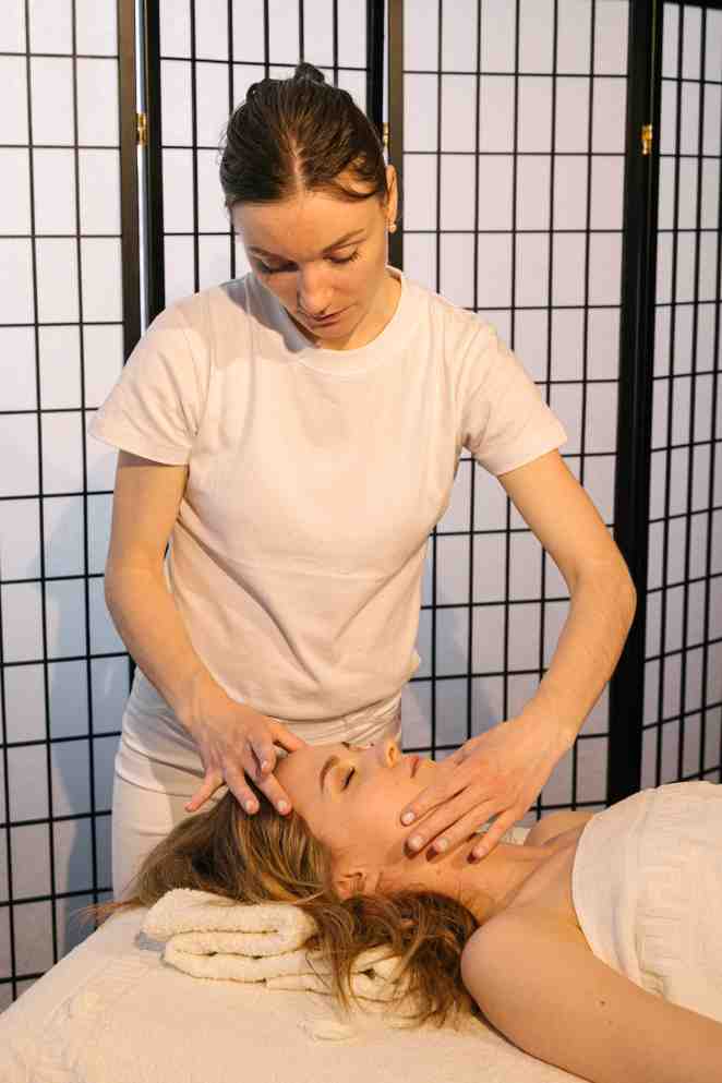 A Massage Therapist Massaging a Woman's Face